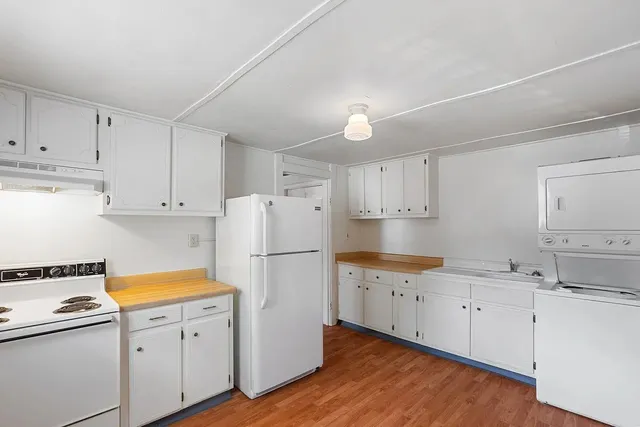 a kitchen with white cabinets and white appliances