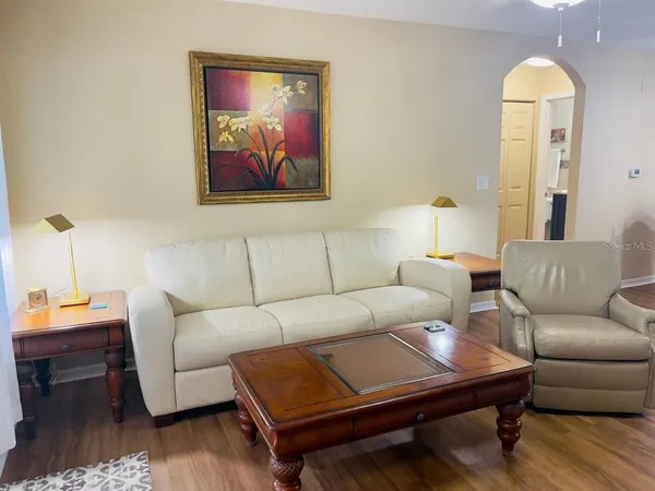 a living room with furniture and a wooden floor