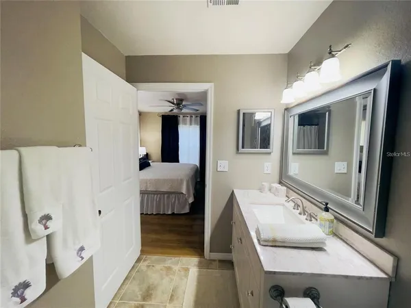 a en suite bathroom with a sink and mirror with bathtub