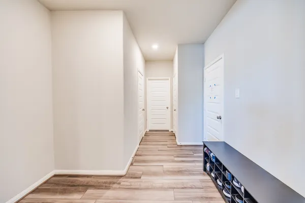 a view of a hallway with wooden floor and staircase