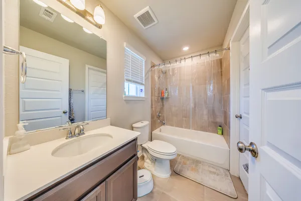 a bathroom with a granite countertop sink a toilet a mirror and shower