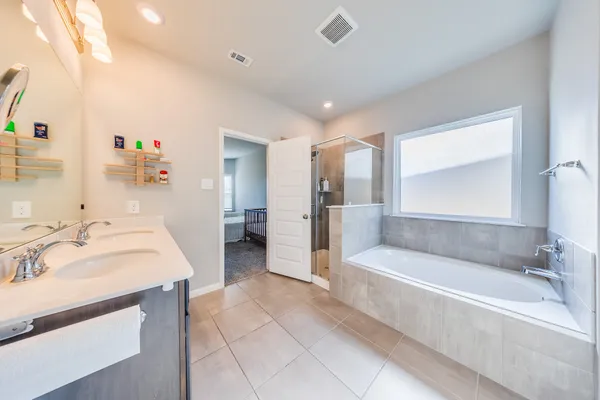 a spacious bathroom with a tub sink and mirror