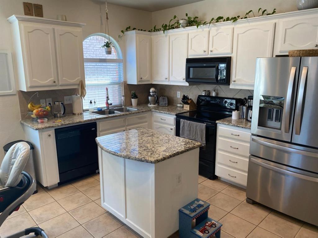 3817 Summersville Lane Fort Worth, TX 76244 - Photo 3 of 18 a kitchen with kitchen island granite countertop a sink appliances and cabinets