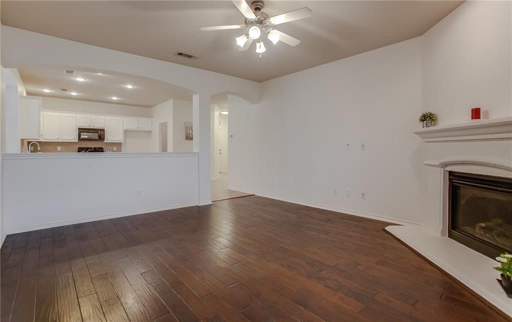 3817 Summersville Lane Fort Worth, TX 76244 - Photo 9 of 18 an empty room with wooden floor fireplace and windows