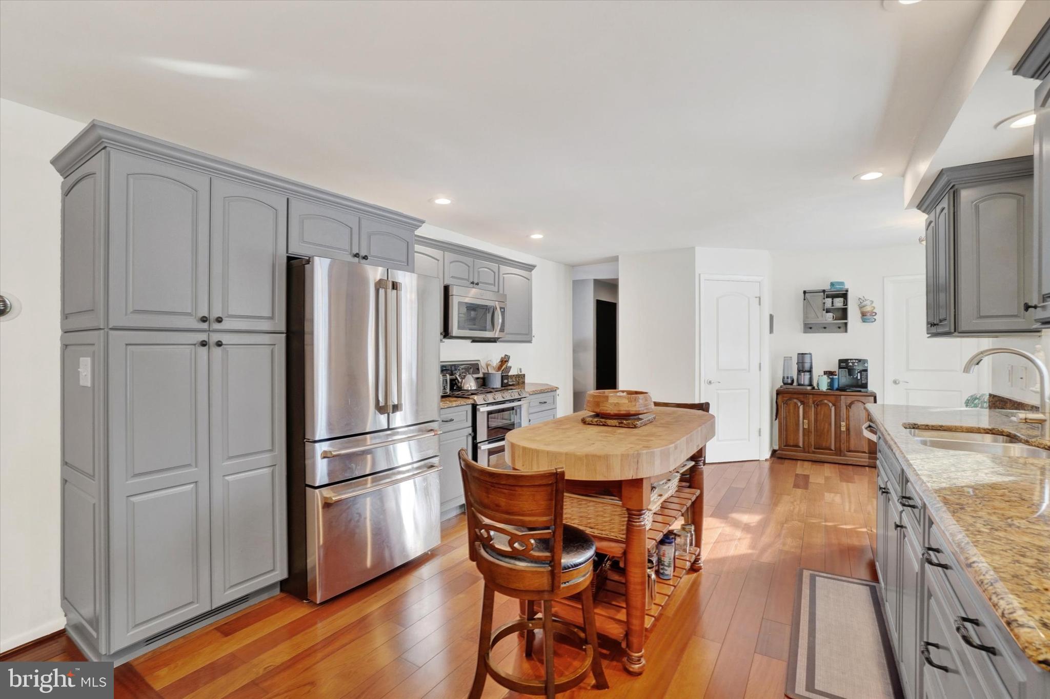 2350 Sutton Road York, PA 17403 - Photo 10 of 37 a kitchen with stainless steel appliances granite countertop a refrigerator a sink a stove a dining table and chairs with wooden floor