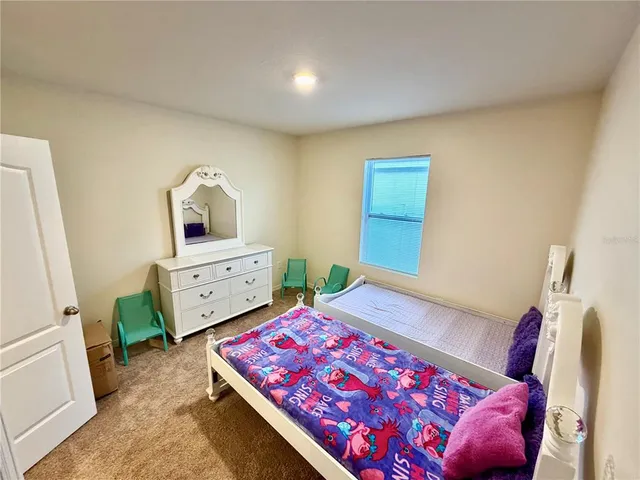 a bedroom with a bed and a view of living room