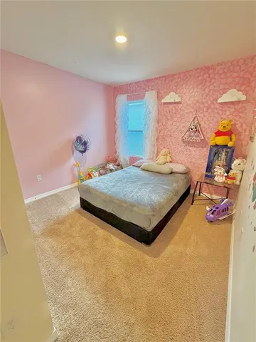 a bedroom with a bed and dresser with mirror