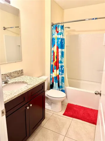 a bathroom with a sink a toilet and shower curtain