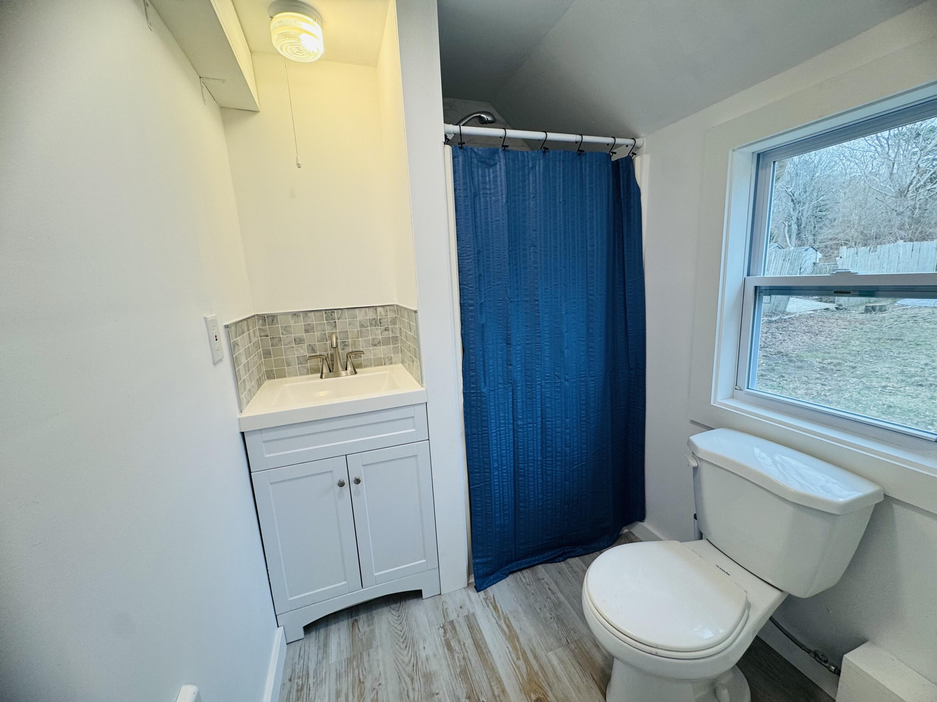 376 Route 6A, Unit 6 Sandwich, MA 02537 - Photo 5 of 6 a bathroom with a toilet a sink and a window