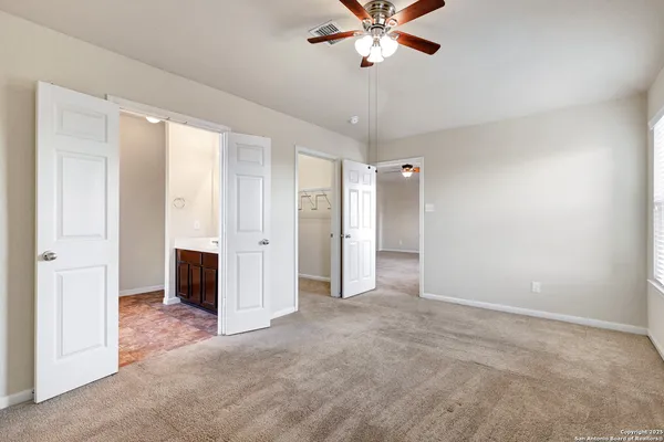 an empty room with a ceiling fan and a window
