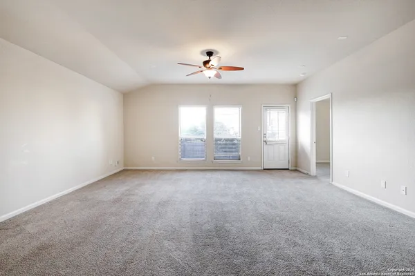 an empty room with windows and cabinet