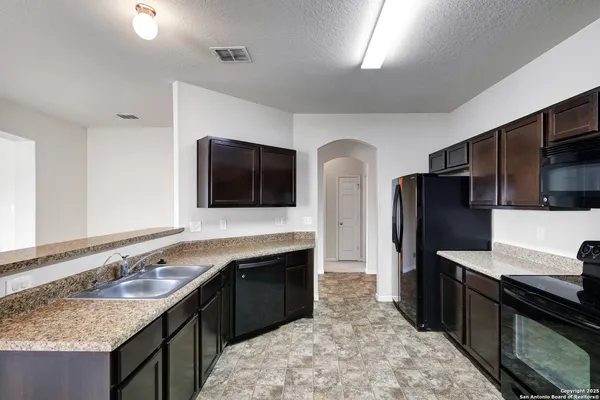 a kitchen with stainless steel appliances granite countertop a sink stove and refrigerator