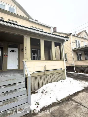 a view of a house with a wooden fence