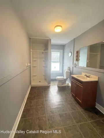 a spacious bathroom with a tub sink and mirror