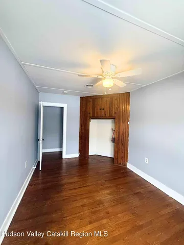 a view of empty room with wooden floor