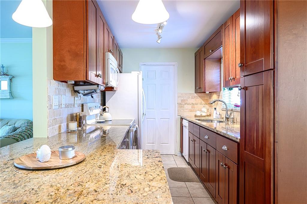 1247 Royal Palm Drive Naples, FL 34103 - Photo 17 of 28 a kitchen with sink and refrigerator