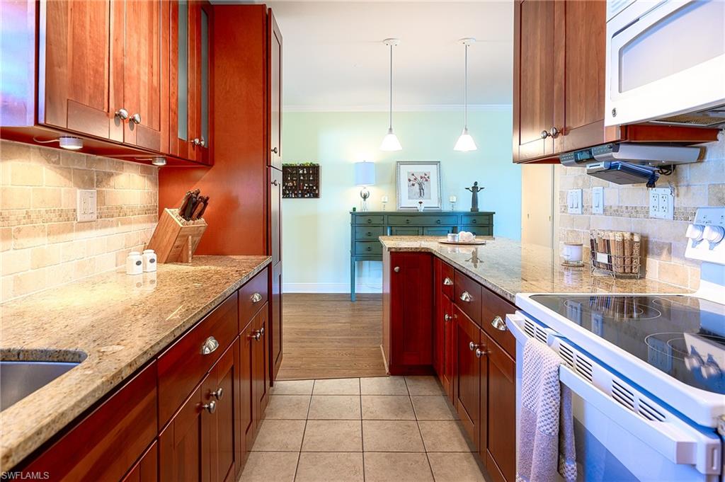 1247 Royal Palm Drive Naples, FL 34103 - Photo 19 of 28 a kitchen with stainless steel appliances granite countertop a sink counter space and cabinets