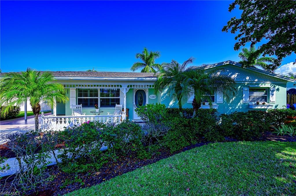 1247 Royal Palm Drive Naples, FL 34103 - Photo 2 of 28 a front view of a house with a garden