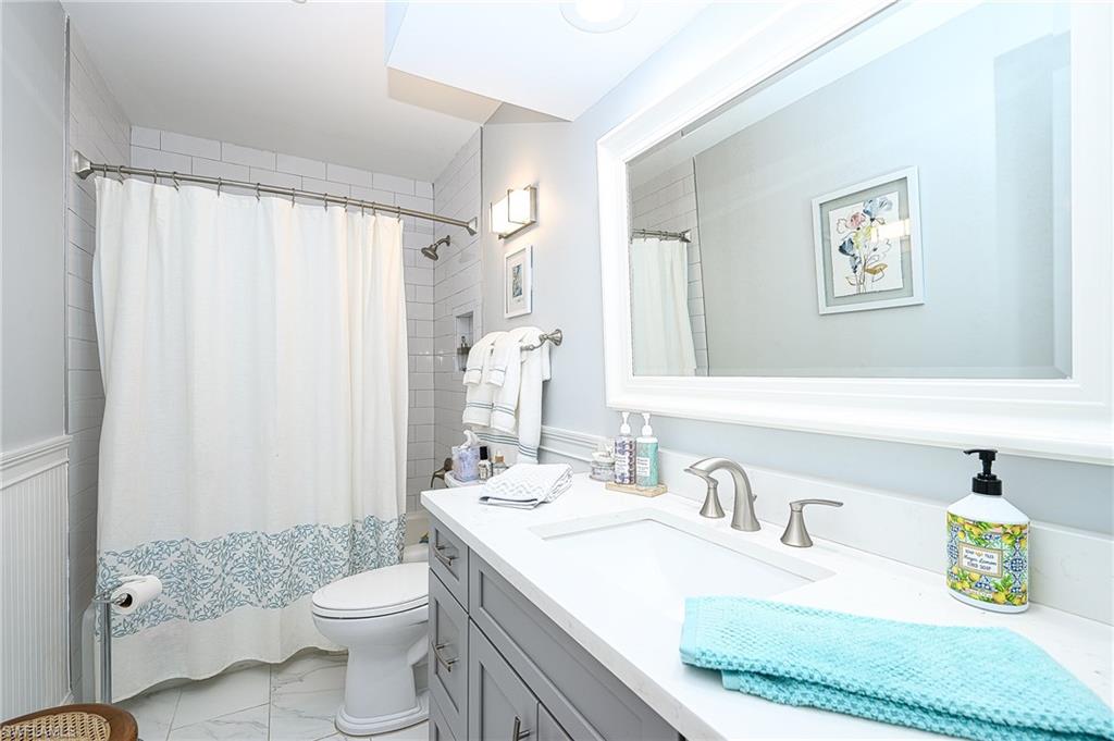 1247 Royal Palm Drive Naples, FL 34103 - Photo 21 of 28 a bathroom with a granite countertop sink mirror vanity and toilet