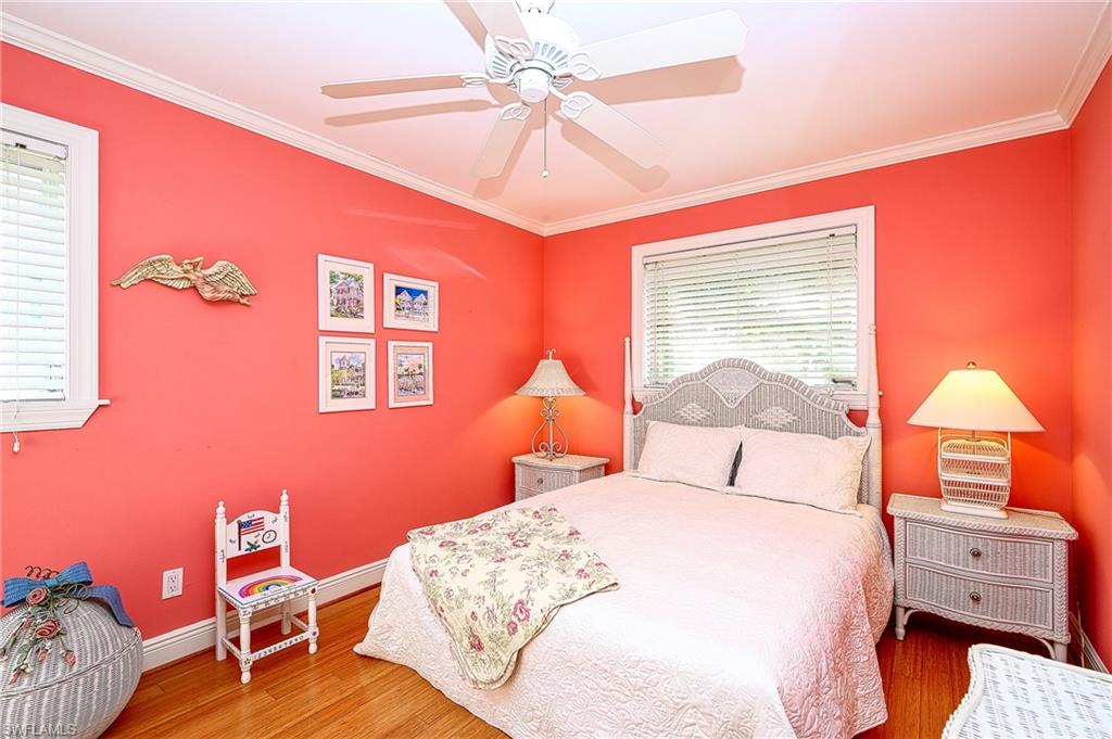 1247 Royal Palm Drive Naples, FL 34103 - Photo 23 of 28 a bedroom with a bed and a chandelier