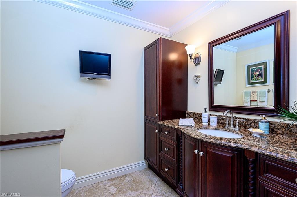 1247 Royal Palm Drive Naples, FL 34103 - Photo 25 of 28 a bathroom with a granite countertop sink and a mirror