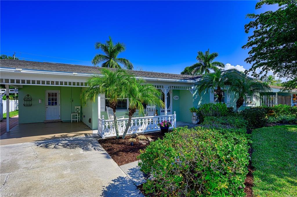 1247 Royal Palm Drive Naples, FL 34103 - Photo 3 of 28 a view of a house with potted plants and a large tree