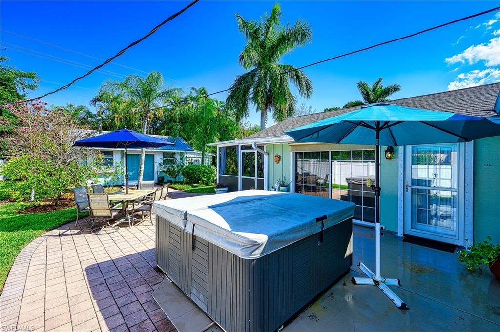 1247 Royal Palm Drive Naples, FL 34103 - Photo 8 of 28 a patio with a table and chairs under an umbrella