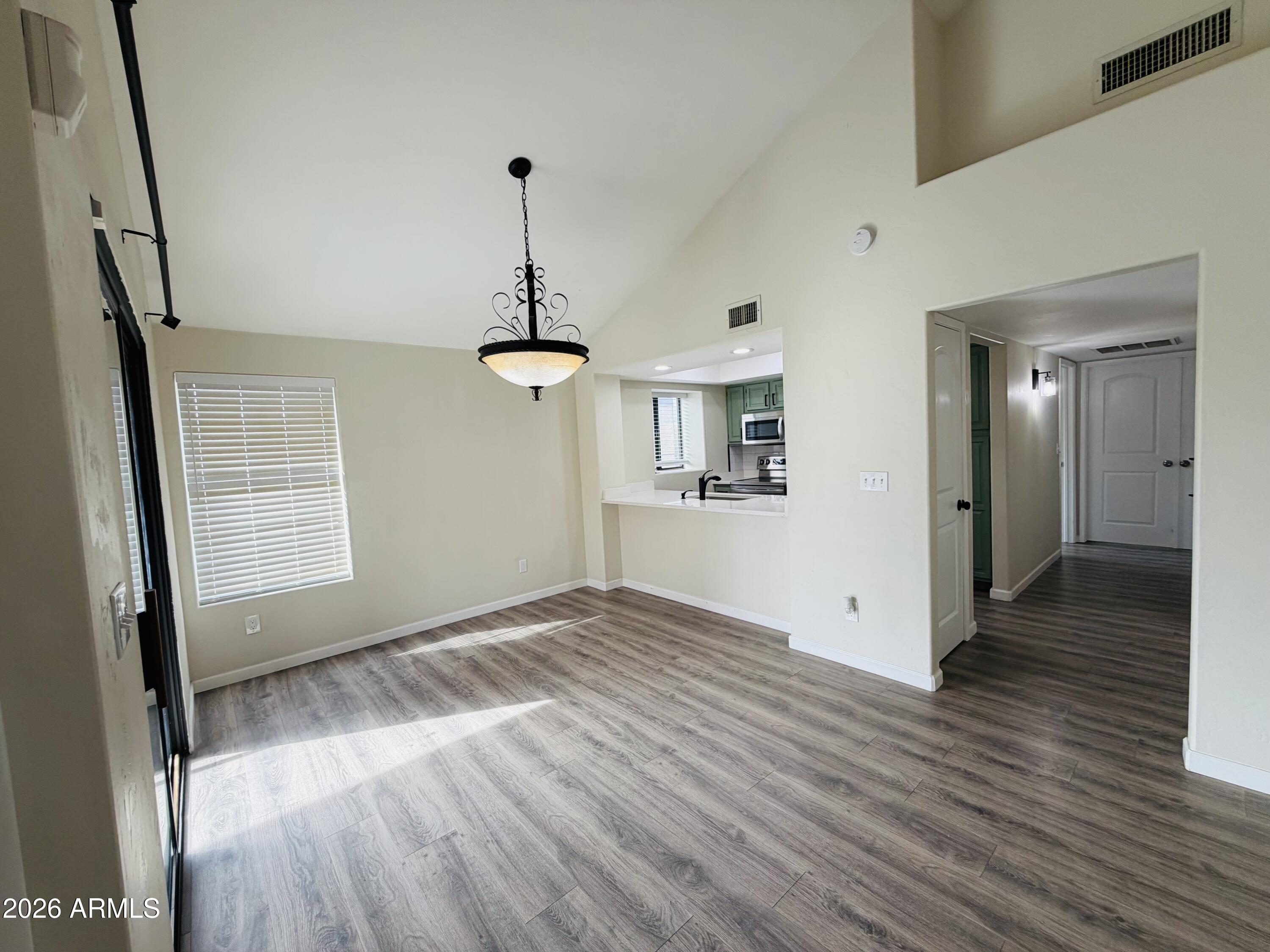 4040 North Weimer Place, Unit 4 Tucson, AZ 85719 - Photo 2 of 12 a view of empty room with wooden floor and stove
