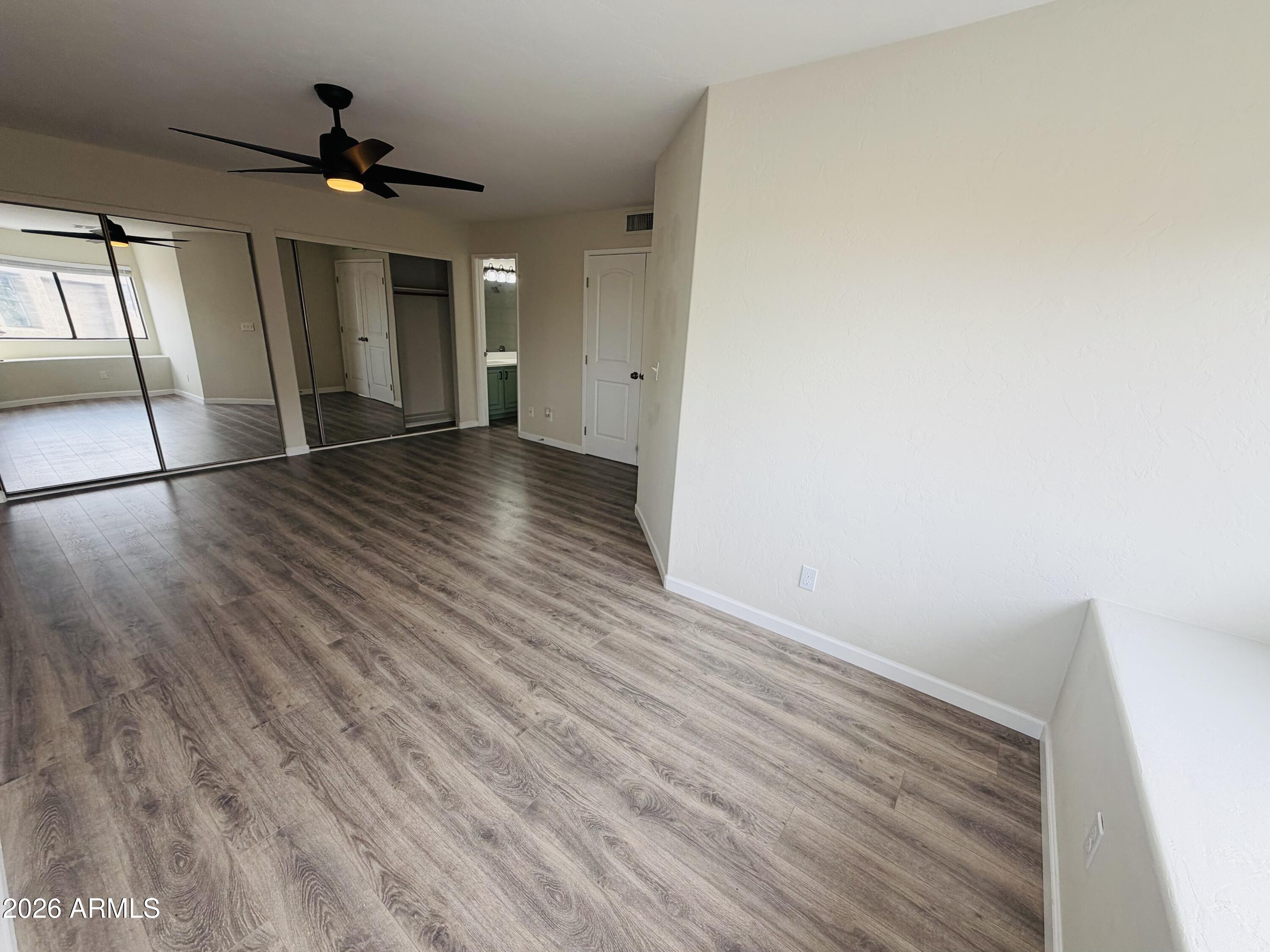4040 North Weimer Place, Unit 4 Tucson, AZ 85719 - Photo 5 of 12 a view of an empty room with wooden floor and a ceiling fan