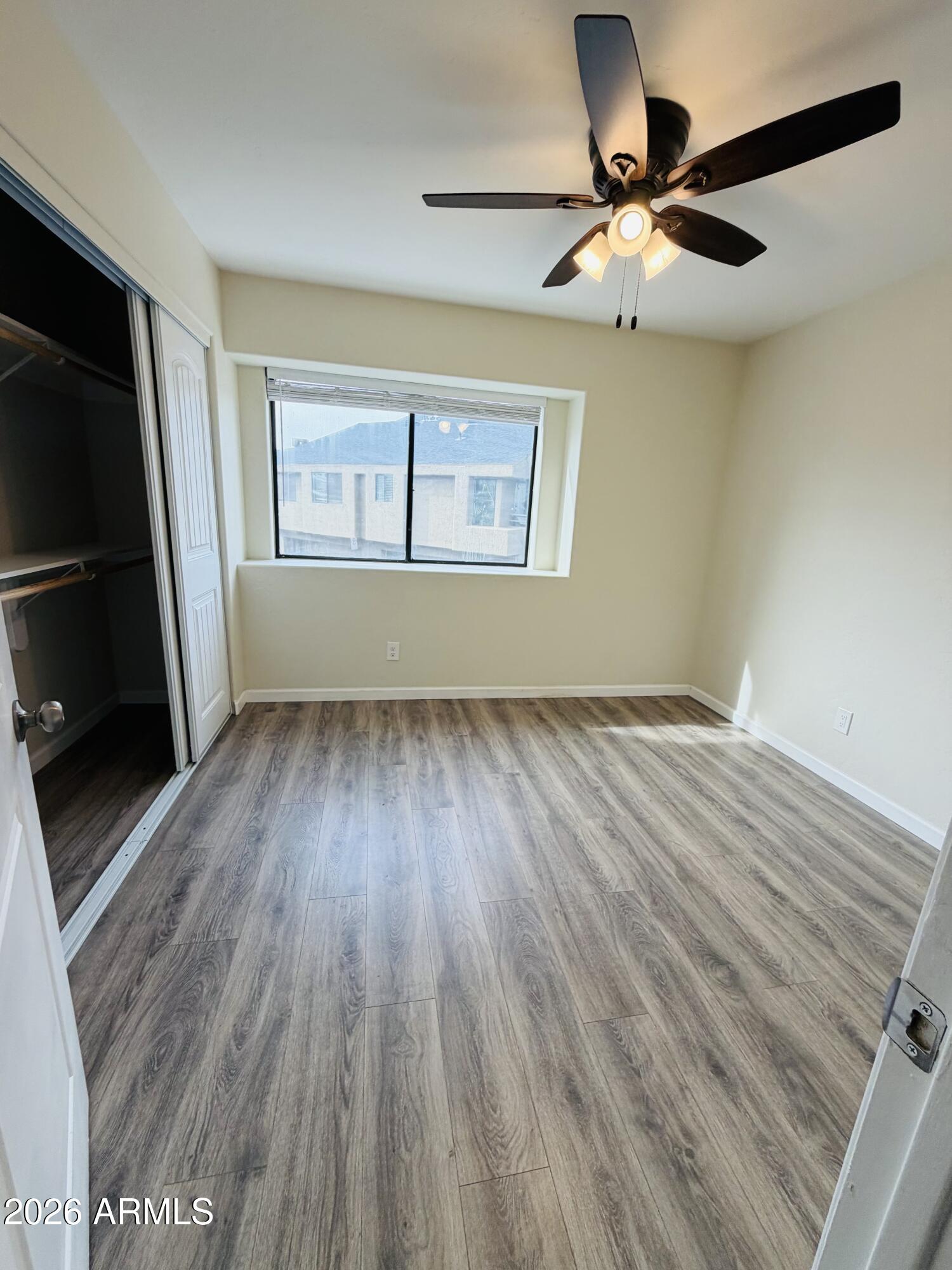 4040 North Weimer Place, Unit 4 Tucson, AZ 85719 - Photo 8 of 12 a view of an empty room with wooden floor and a window