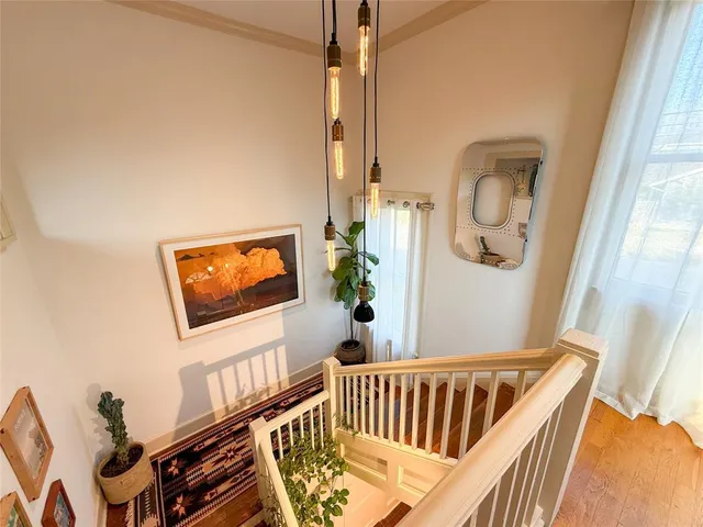 a view of staircase with lots of frames on wall and a window