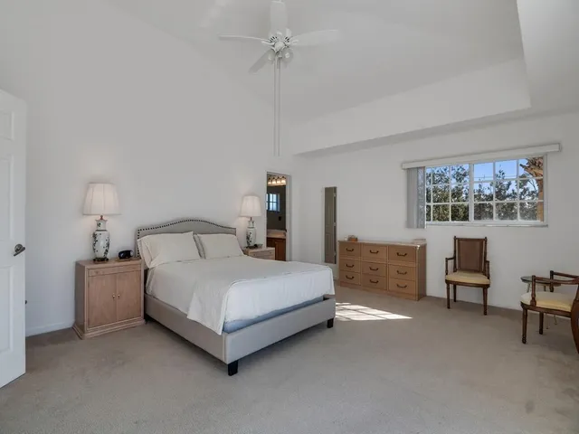 a spacious bedroom with a bed a table and chair