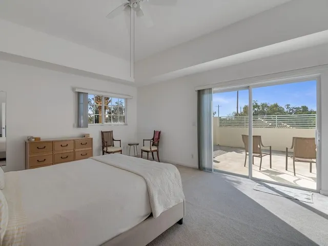 a bedroom with a bed and a large window
