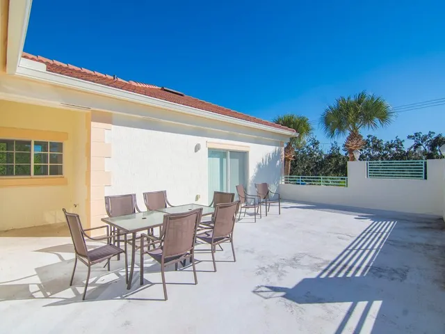 a view of a house with backyard and sitting area