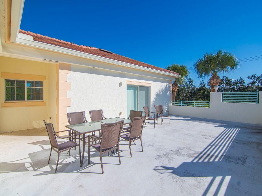 520 7th Square Southwest, Unit 201 Vero Beach, FL 32962 - Photo 20 of 46 a view of a patio with table and chairs and potted plants