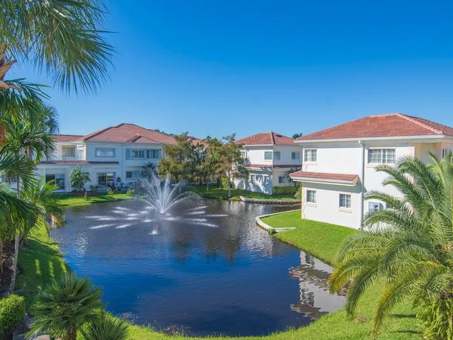 a view of a house with a yard and a pond