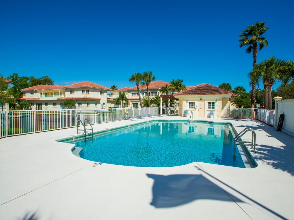 520 7th Square Southwest, Unit 201 Vero Beach, FL 32962 - Photo 37 of 46 a view of a swimming pool with a lawn chairs under an umbrella