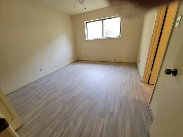 a view of an empty room with a fireplace and a window