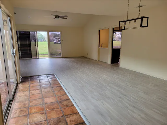 a kitchen with stainless steel appliances granite countertop a refrigerator a sink dishwasher and wooden cabinets with wooden floor