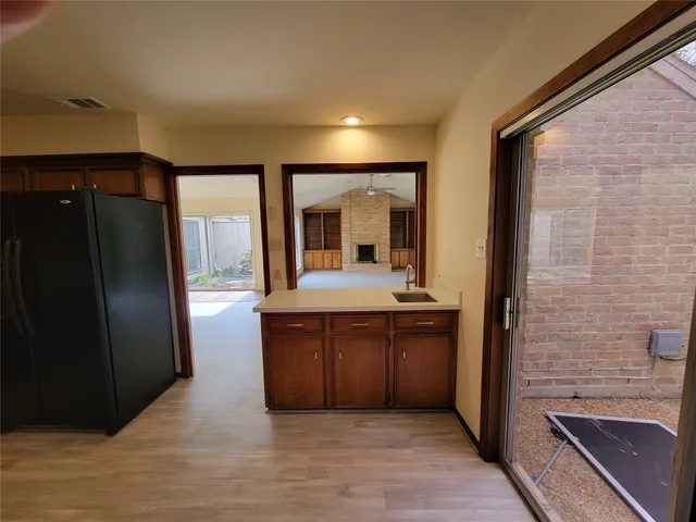 a kitchen with stainless steel appliances granite countertop a refrigerator a sink and wooden cabinets