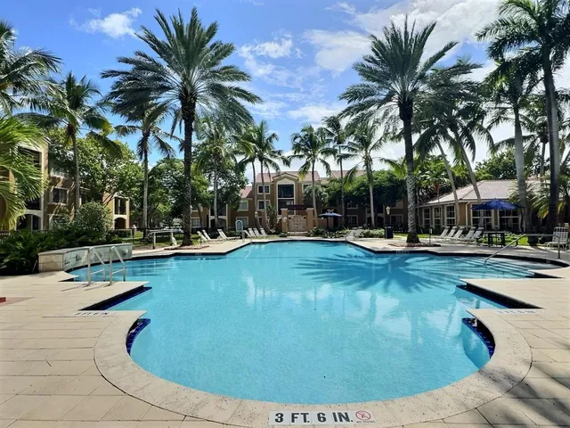 a view of swimming pool with outdoor seating and house in the background
