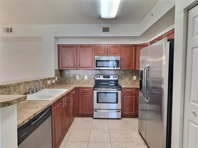a kitchen with a sink stainless steel appliances and cabinets