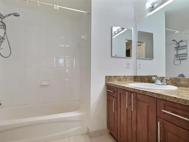 a bathroom with a granite countertop sink a toilet and shower