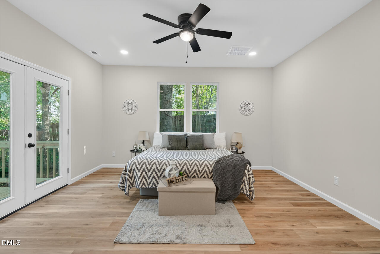 606 North Maple Street Durham, NC 27703 - Photo 32 of 51 a spacious bedroom with a large bed chandelier and a window