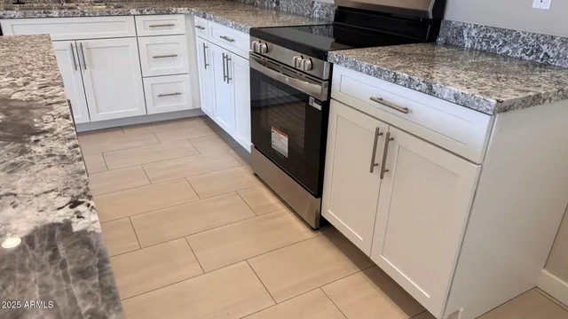 a kitchen with granite countertop white cabinets and white appliances