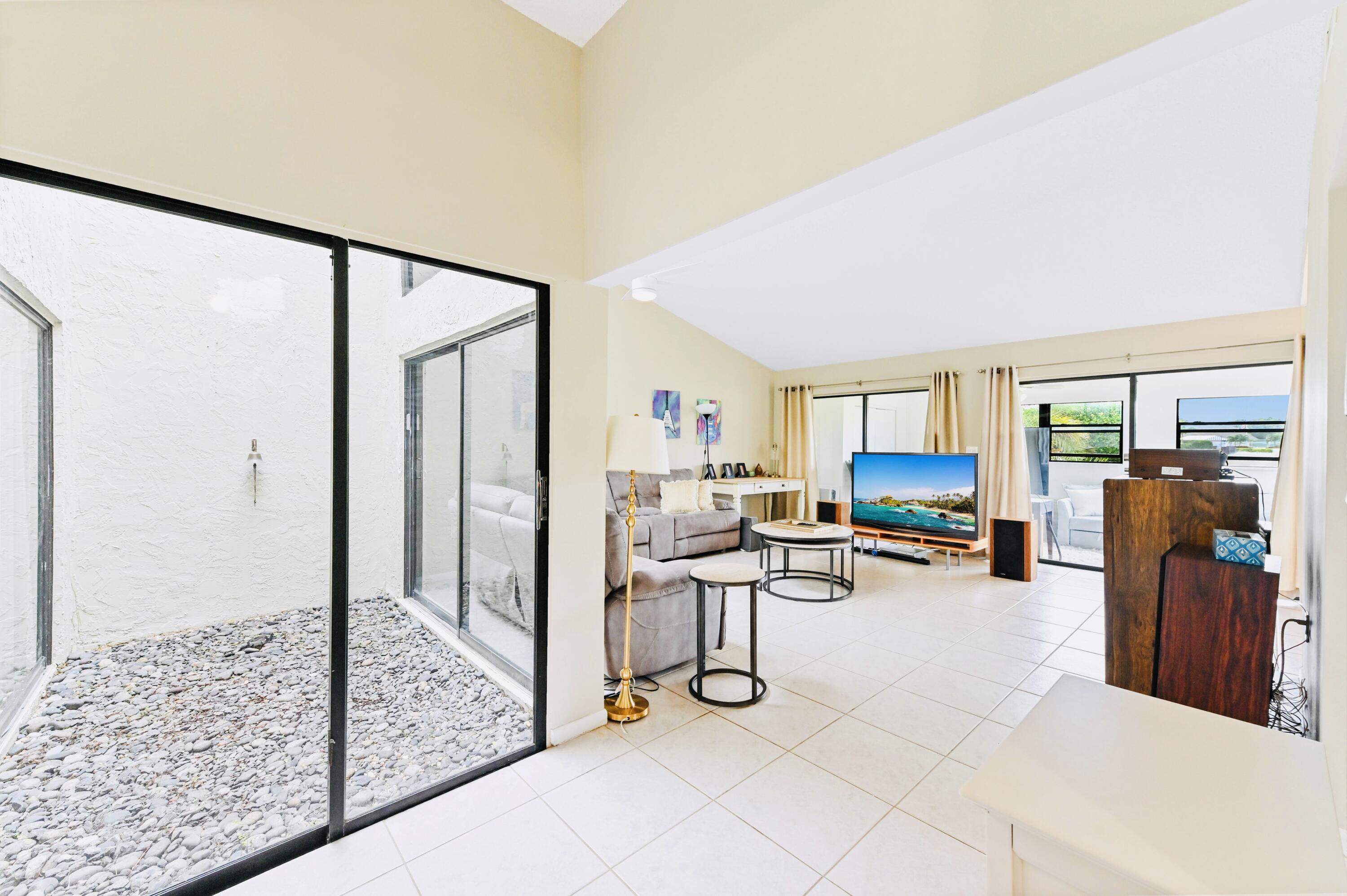 2749 Southwest 5th Street Delray Beach, FL 33445 - Photo 19 of 55 a living room with furniture a flat screen tv and a table