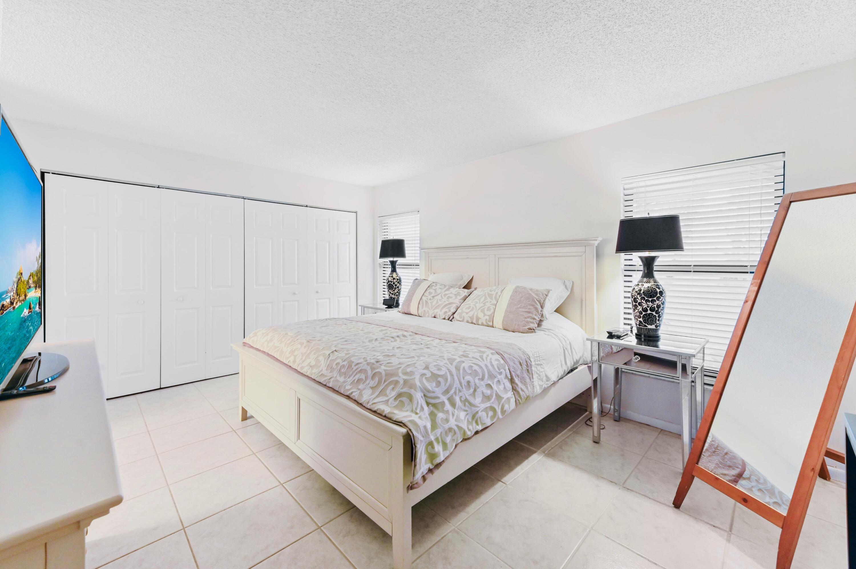 2749 Southwest 5th Street Delray Beach, FL 33445 - Photo 29 of 55 a bedroom with a bed and a flat tv screen on a dresser