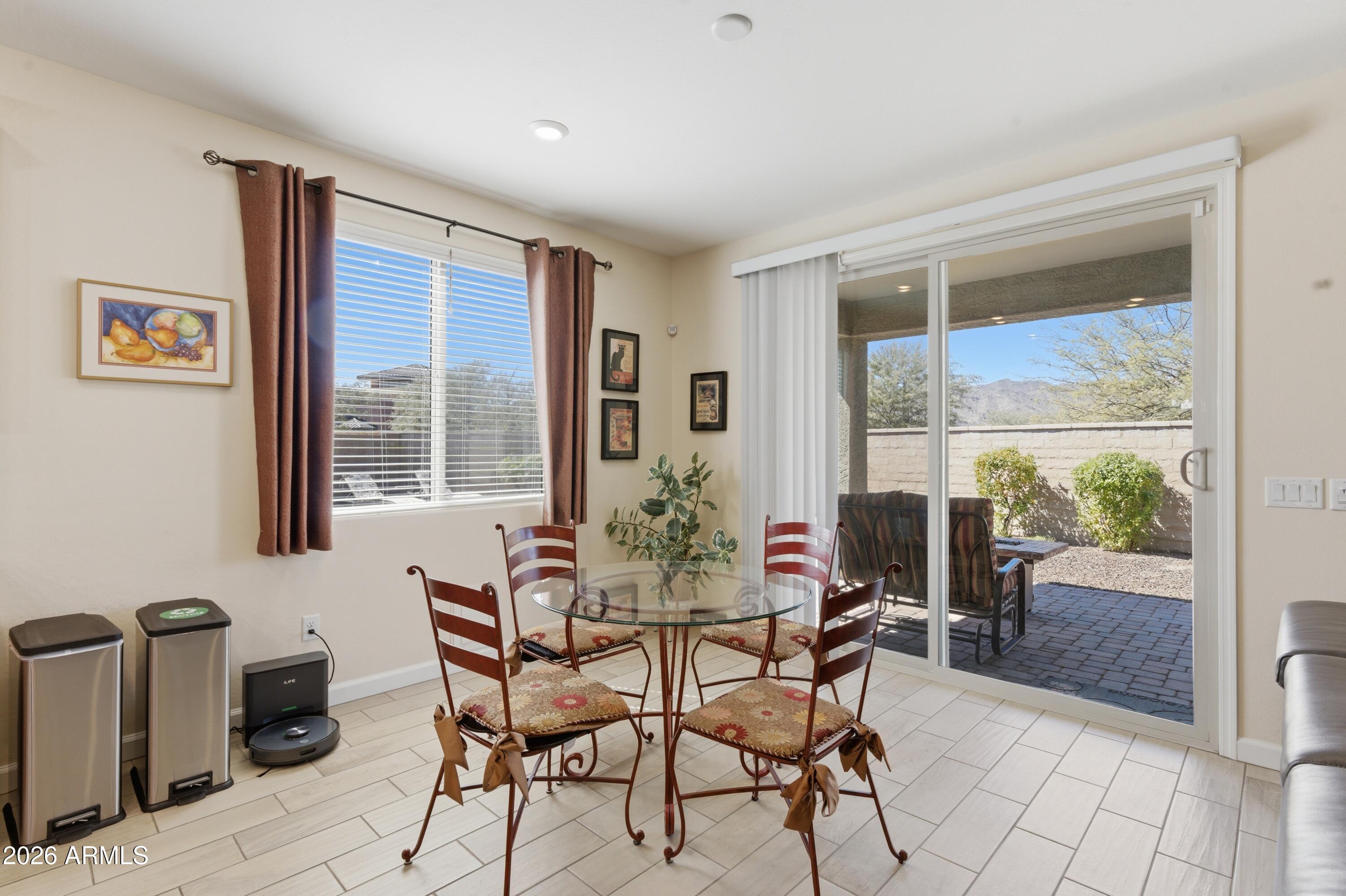 4654 North 204th Lane Buckeye, AZ 85396 - Photo 14 of 41 a view of a dining room with furniture large windows and wooden floor