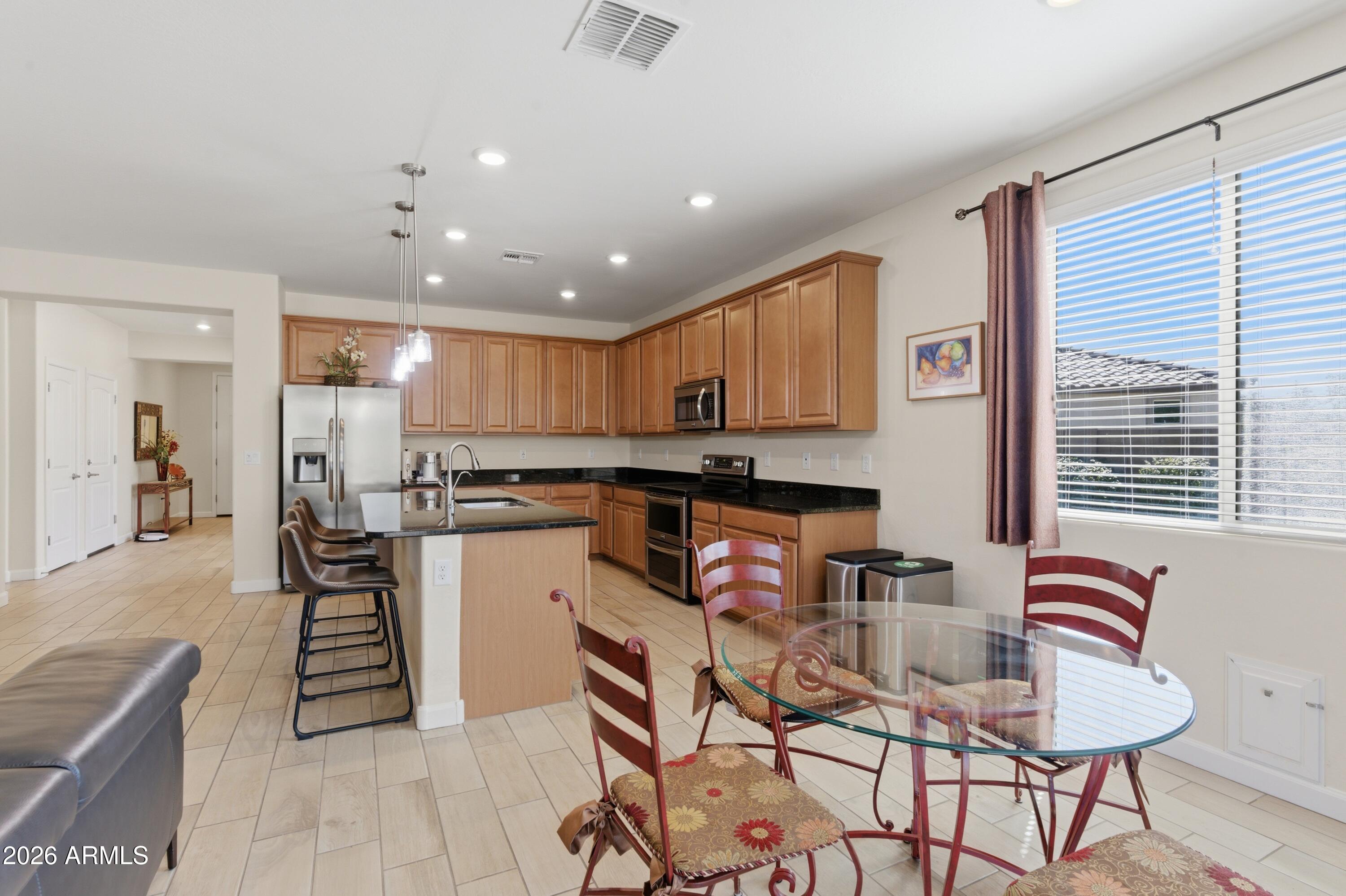 4654 North 204th Lane Buckeye, AZ 85396 - Photo 15 of 41 a kitchen with a refrigerator and a stove top oven