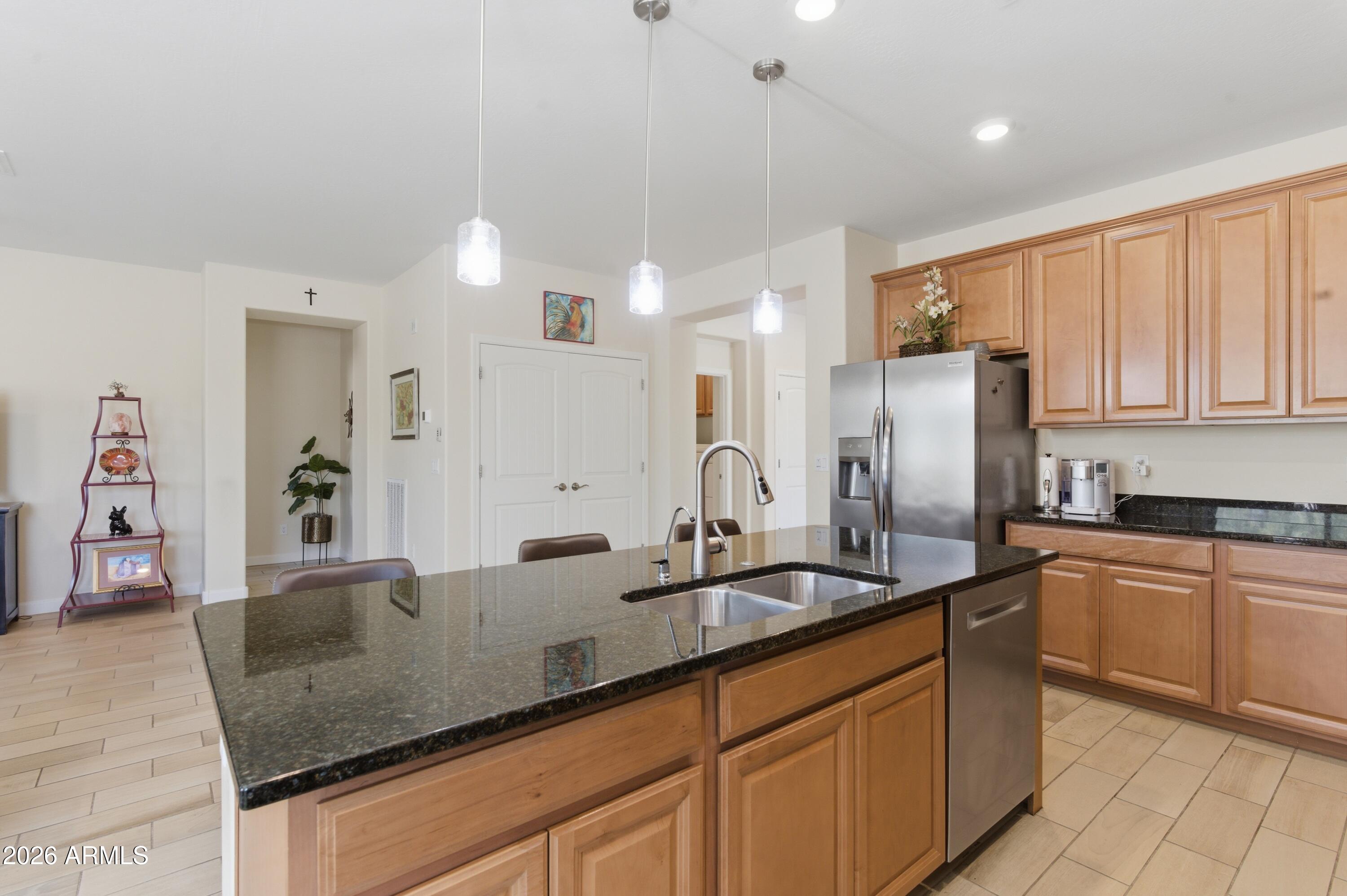 4654 North 204th Lane Buckeye, AZ 85396 - Photo 16 of 41 a kitchen with granite countertop a sink stainless steel appliances and cabinets